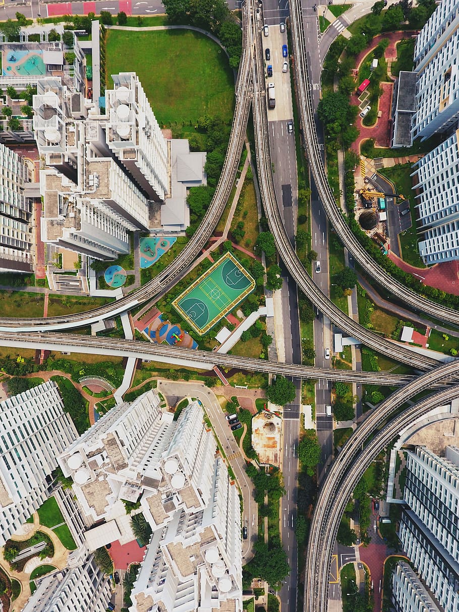 aerial photography of winding road, arial view of city with buildings during daytime HD wallpaper