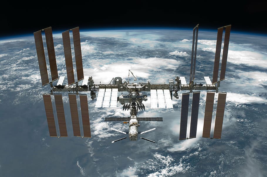 grey and brown satellite overlooking Earth, international space station