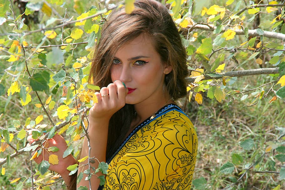 close up of woman in yellow shirt surrounded by plants, girl