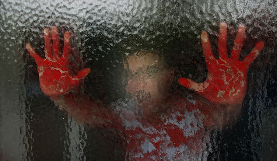 person holding glass with bloody hands, glass wall, frosted glass