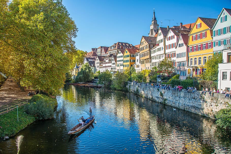 people riding on wooden boat while sailing on water, tübingen