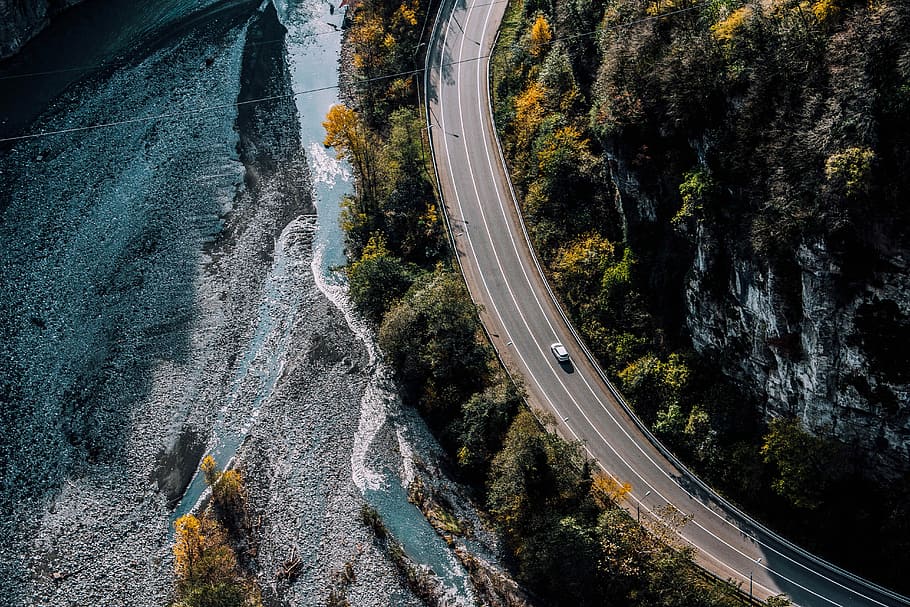 white car on road beside body of water, bend, cliff, mountain HD wallpaper