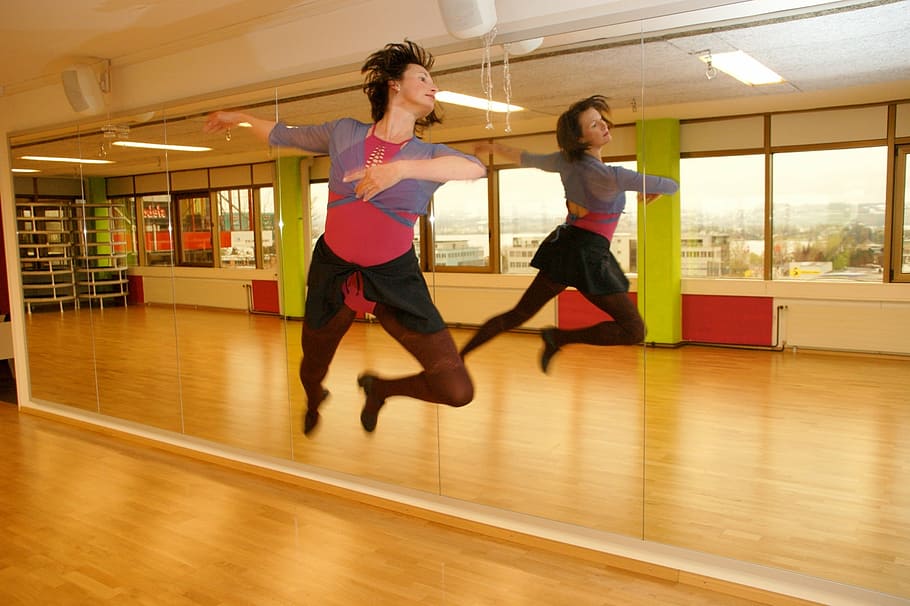 person wearing black short dancing near glass mirror, dance, gymnastics