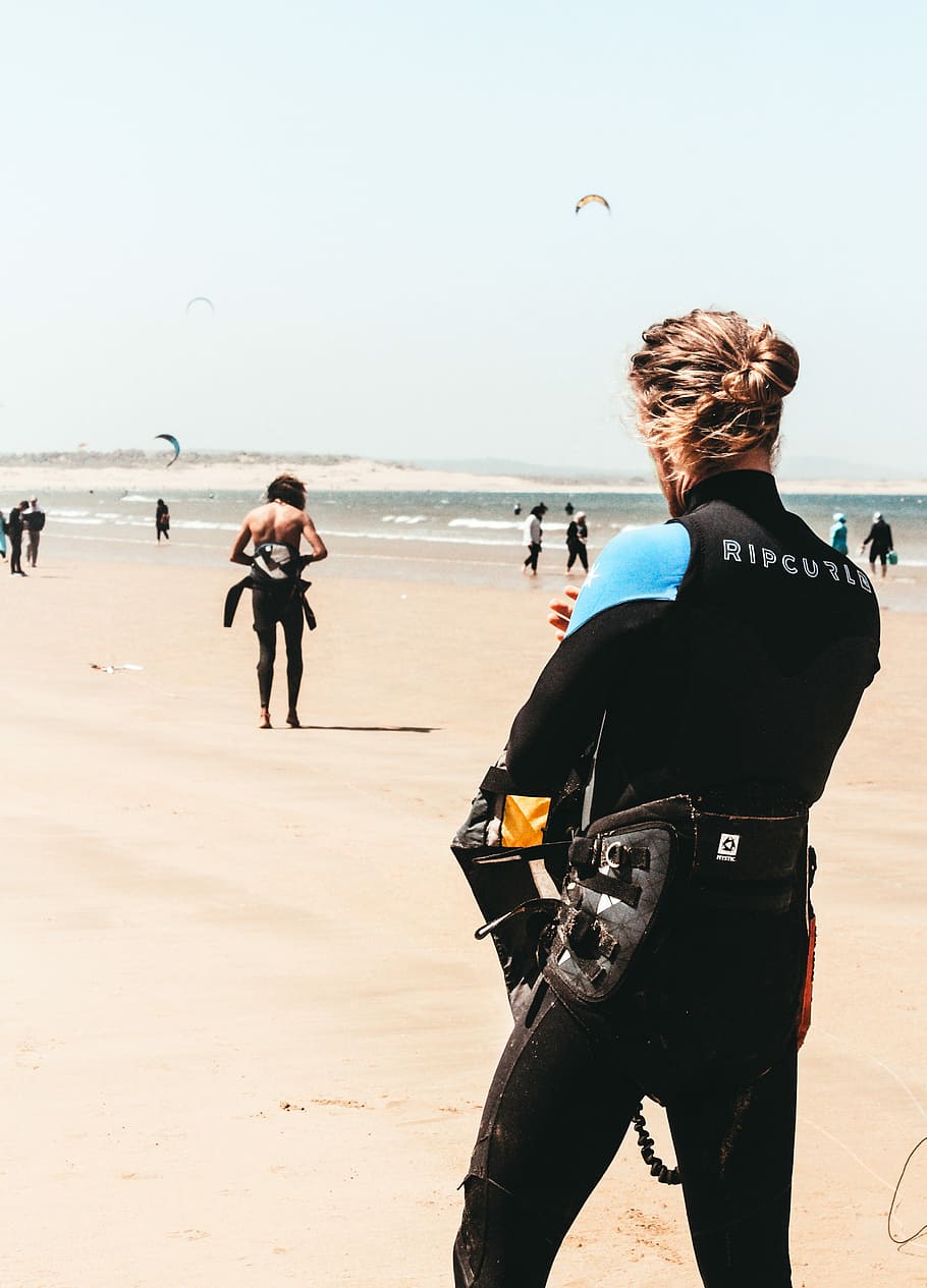 woman standing on seashore, man standing while wearing wet suit near seashore during daytime, HD wallpaper