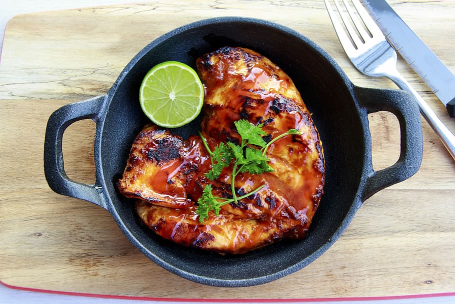 roast pork on cast iron pan topped with parsley and lime slice on side HD wallpaper