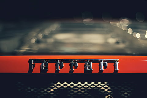 closeup photography of Ferrari logo, tilt shift lens photography of silver Ferrari emblem HD wallpaper