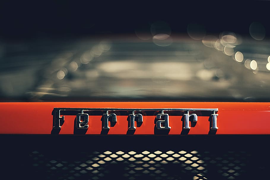 closeup photography of Ferrari logo, tilt shift lens photography of silver Ferrari emblem HD wallpaper