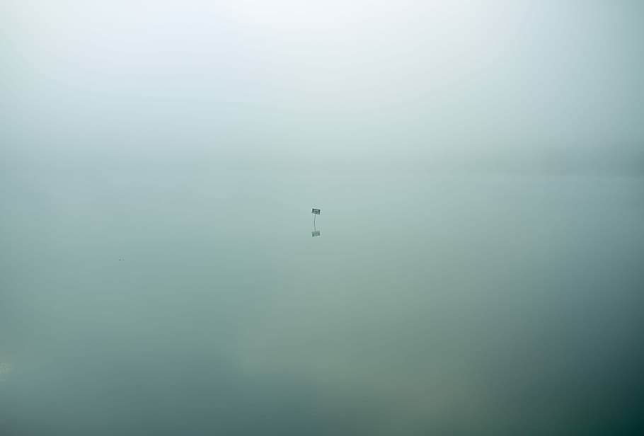 Single isolated sign sits in eerie still waters covered in clouds, untitled HD wallpaper
