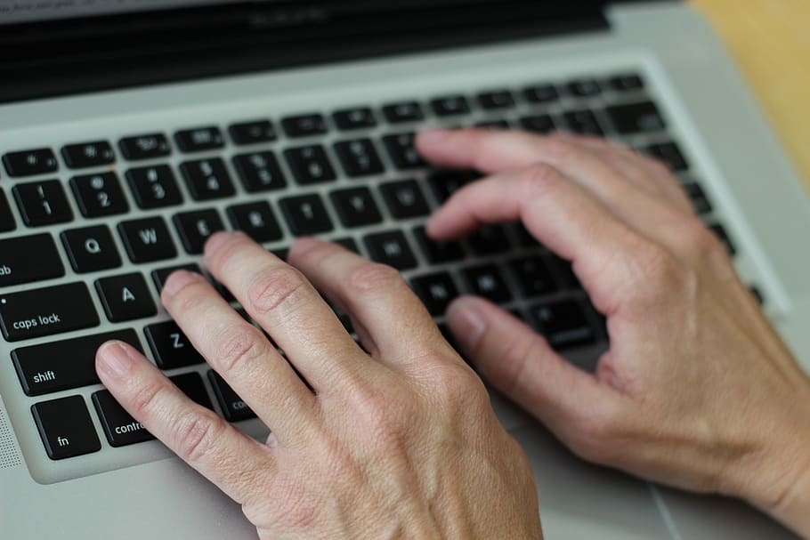 person's hand on MacBook Pro, hands on keyboard, computing HD wallpaper