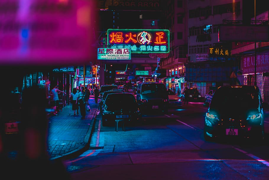 midnight city road, cars parked near sidewalk with people walking at night