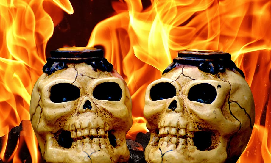 two human skull decors near flame, skull and crossbones, creepy