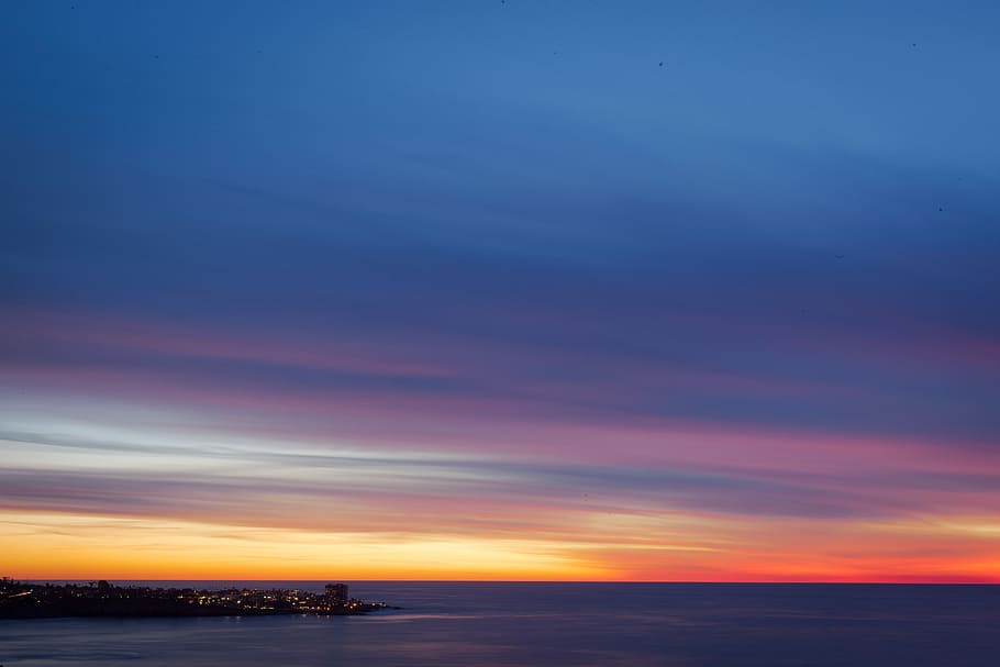 cityscape facing sea, landscape photography of body of water during golden hour HD wallpaper
