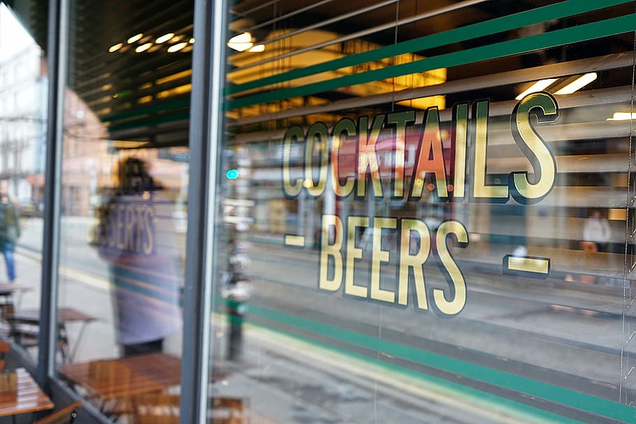 clear glass wall divider of a shop, person in white shirt standing beside cocktails beers store HD wallpaper