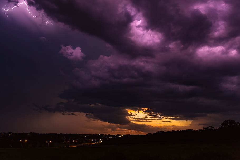 city at night under purple and orange cloudy sky, city under nimbus clouds HD wallpaper