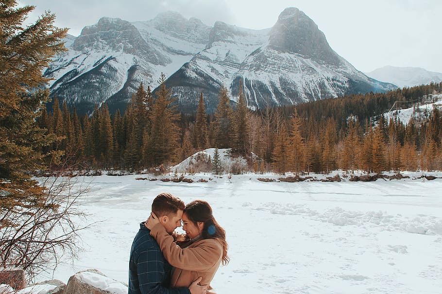 man and woman embracing each other, man and woman about to kiss in front of mountain HD wallpaper