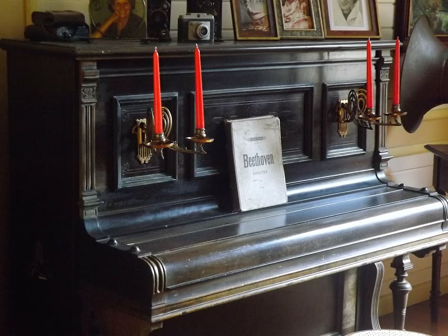 black upright piano, beethoven, candles, chandeliers, old house
