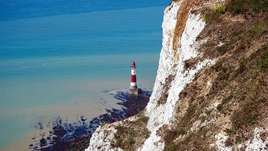 white and red lighthouse near ocean water during daytime high angle photography HD wallpaper