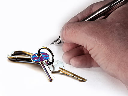 person's holding stainless steel ballpoint pen beside keys HD wallpaper