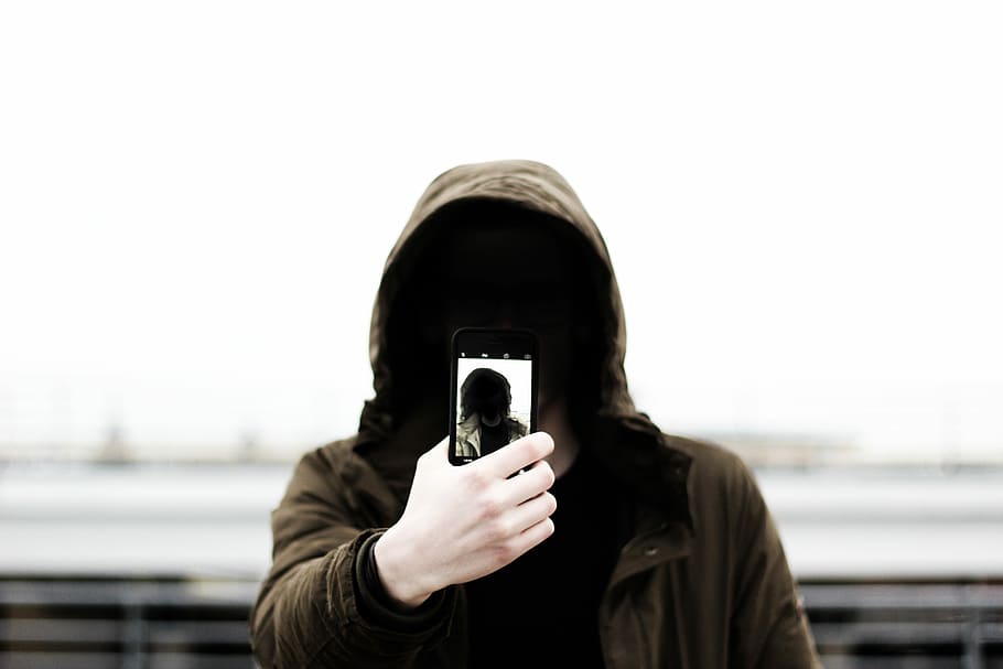 person holding phone wearing brown hoodie, people, one Person HD wallpaper