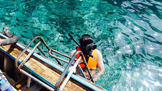 Eric, person wearing red and yellow self-flotation device and black snorkel goggles climbing on ladder mounted on boat HD wallpaper