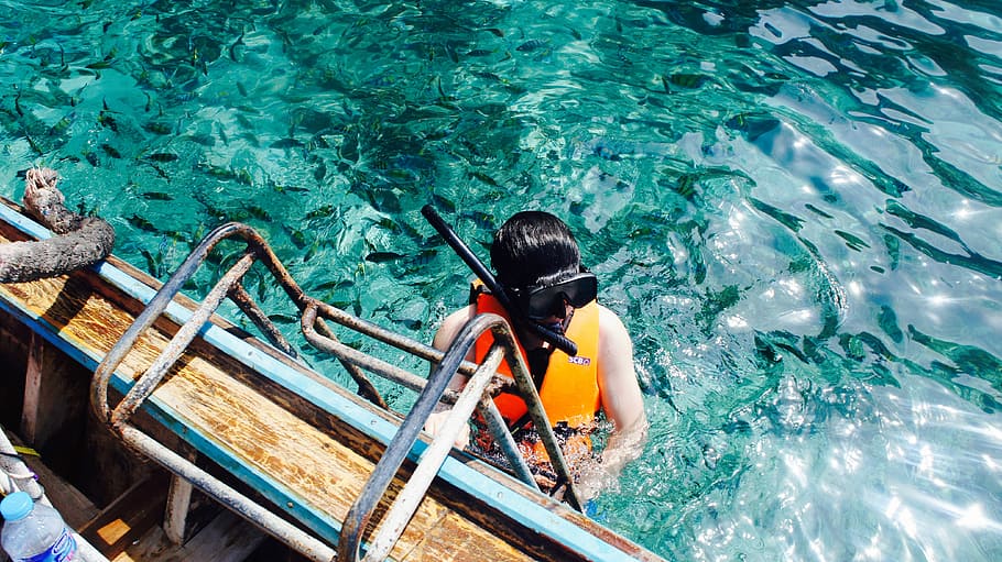 Eric, person wearing red and yellow self-flotation device and black snorkel goggles climbing on ladder mounted on boat HD wallpaper