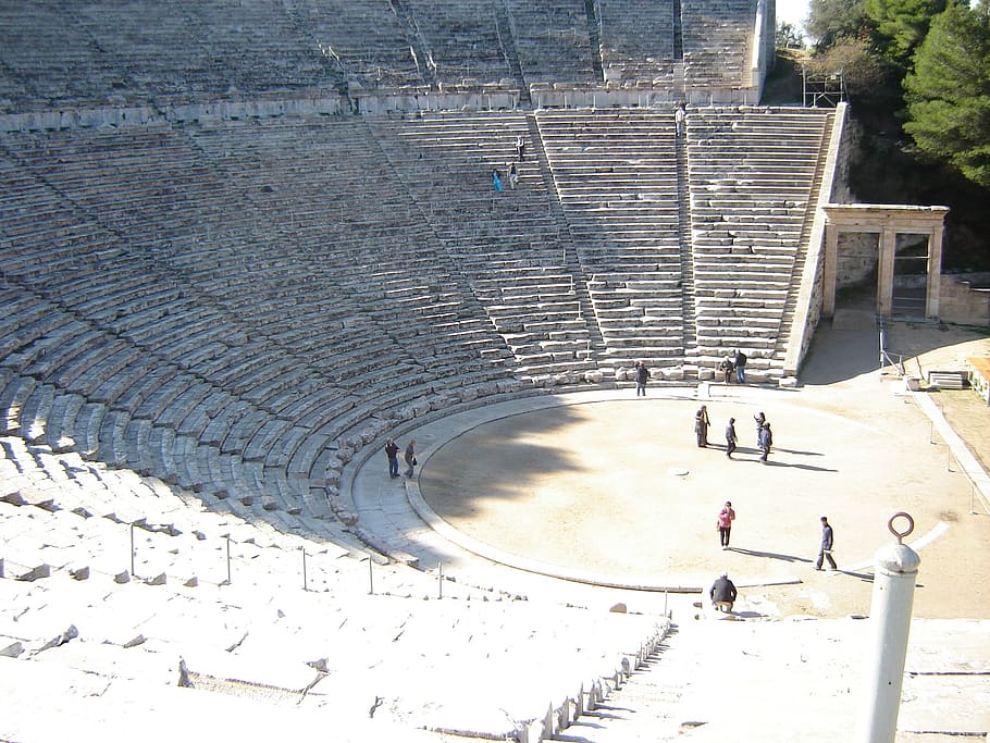 group of people stand on half-circle coliseum, epidaurus, amphitheater