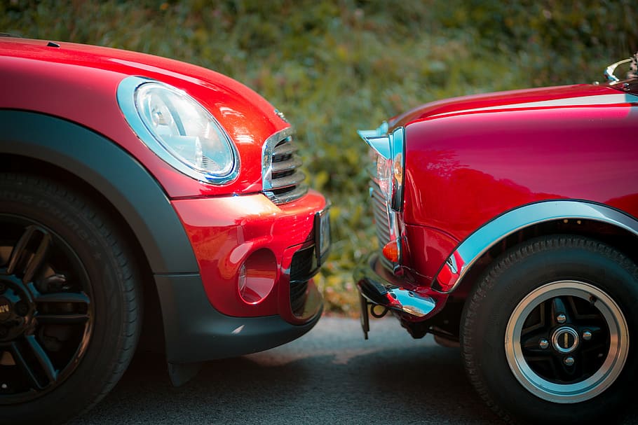 closeup photography of red Mini Cooper and classic red Mini Cooper during daytime HD wallpaper