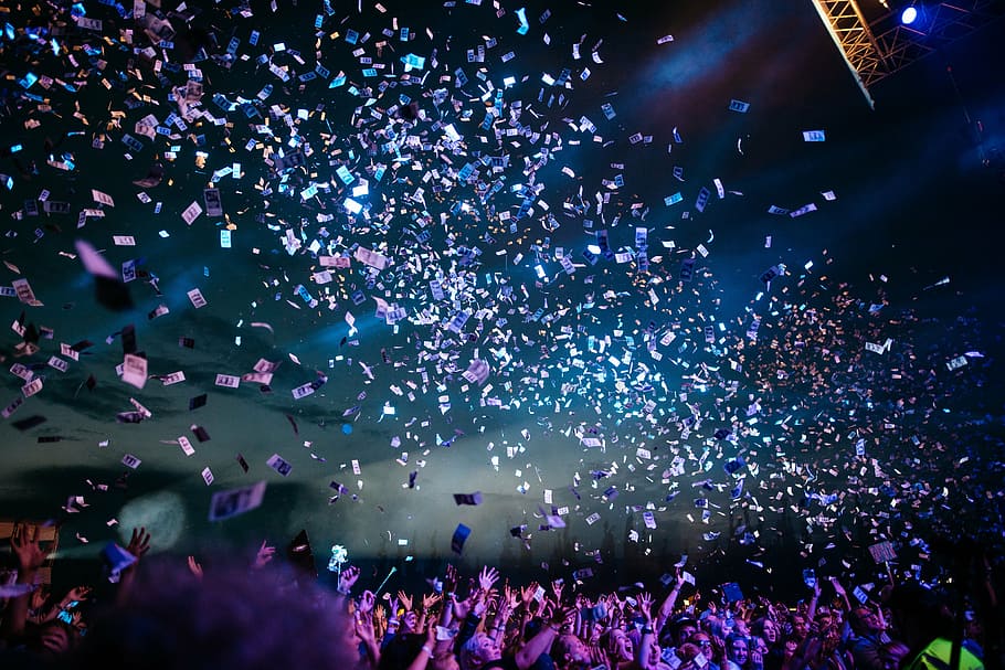 crowded area with banknotes flying, confetti, concert, people
