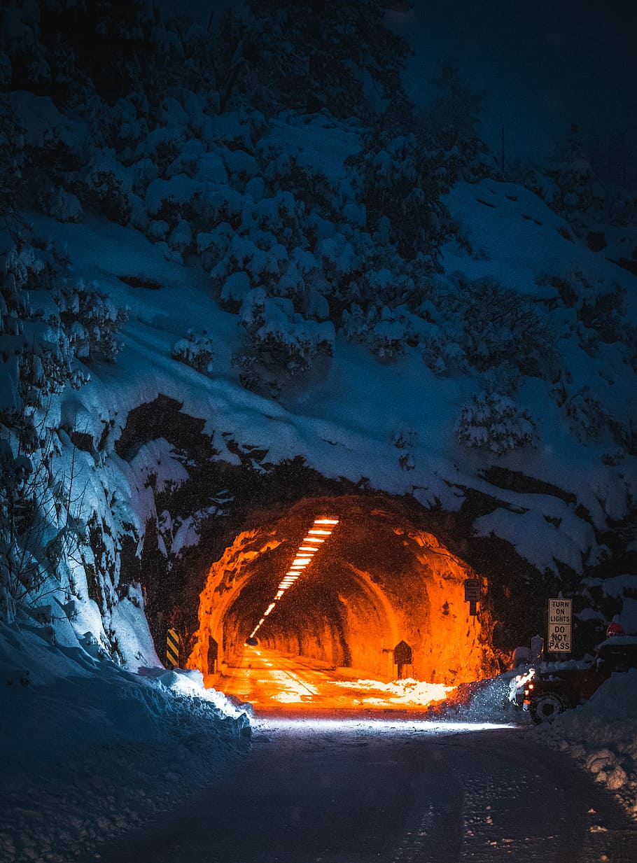 road tunnel in mountain, landmark photography of tunnel road covered with snow with orange lights HD wallpaper
