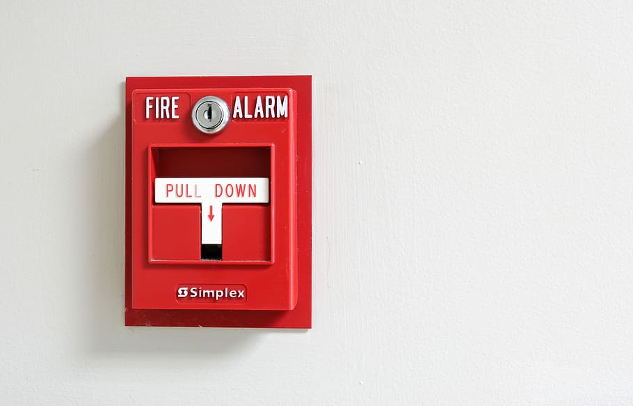 Fire alarm on black and white concrete wall. Warning and security system.  Emergency equipment for safety