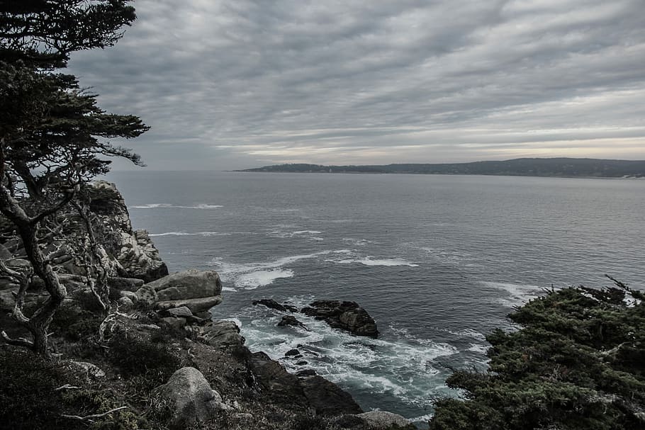 coastline with rocky seashores, sea near mountain under white clouds HD wallpaper