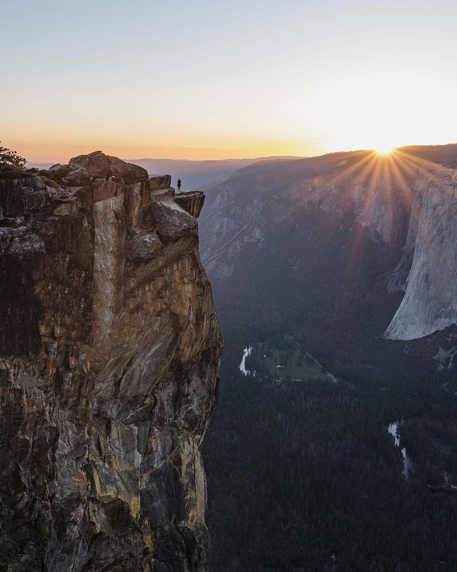 person standing on brown hill during sunset, person on mountain near cliff during sunrise HD wallpaper