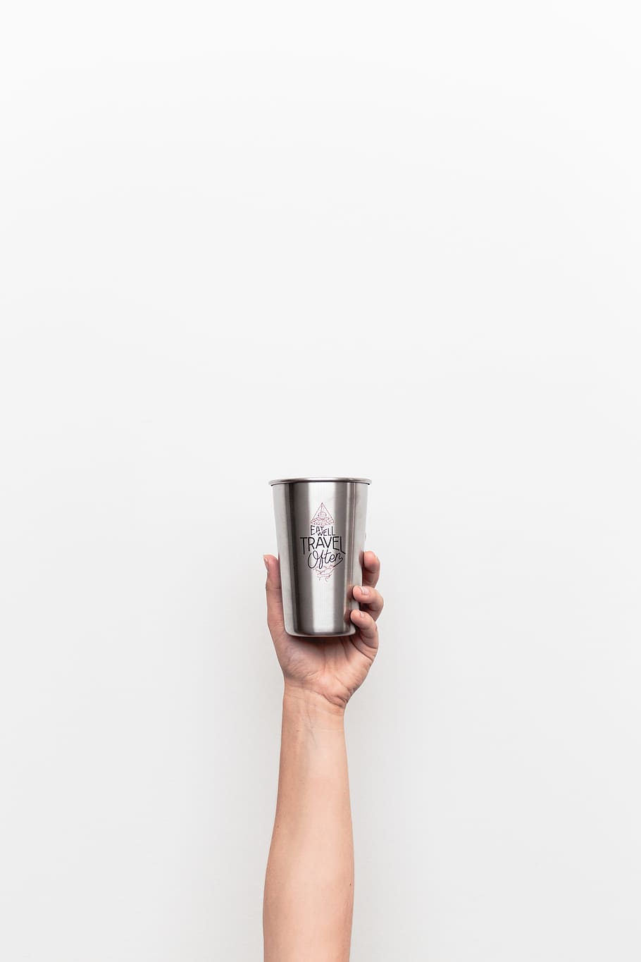 person holding gray stainless steel drinking cup, person holding stainless steel cup