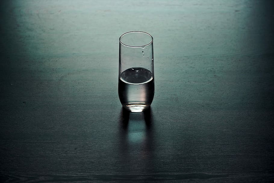 clear drinking glass on brown wooden surface, tilt lens photography of clear glass cup filled with water on table