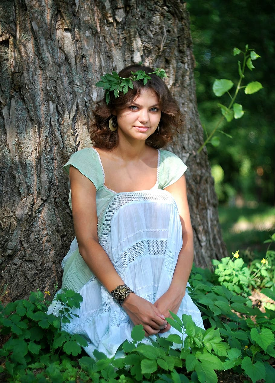 woman wearing teal scoop-neck cap-sleeved dress sitting in front of tree surrounded by green leaf plants, HD wallpaper