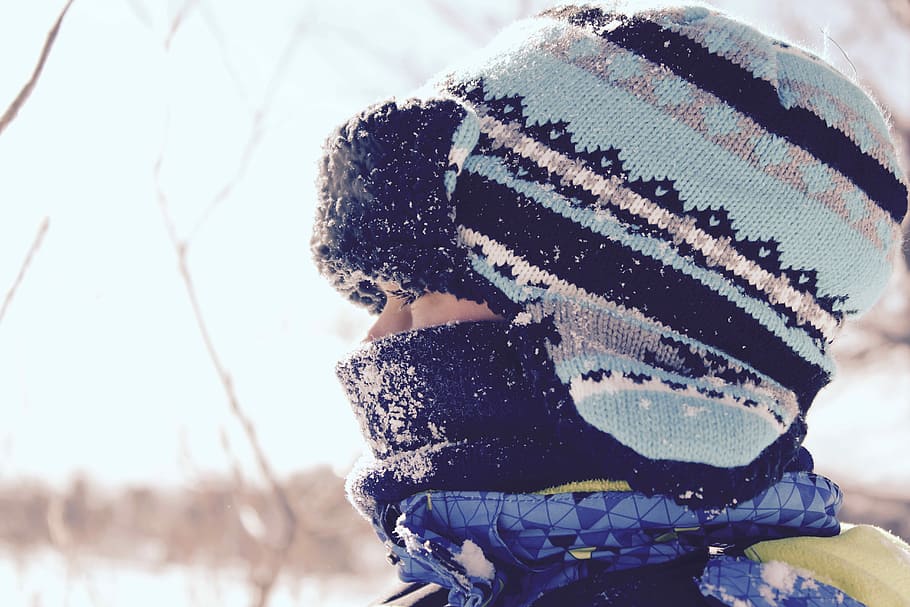 person wearing black and teal striped hat at snowtime, closeup photo of person wearing teal and black knit hat HD wallpaper