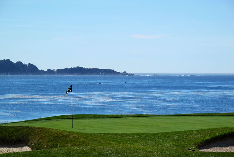 golf course near body of water, flag on green grass field beside body of water HD wallpaper