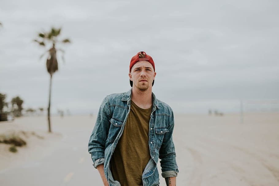 man standing on white sand and doing pose, people, guy, denim HD wallpaper