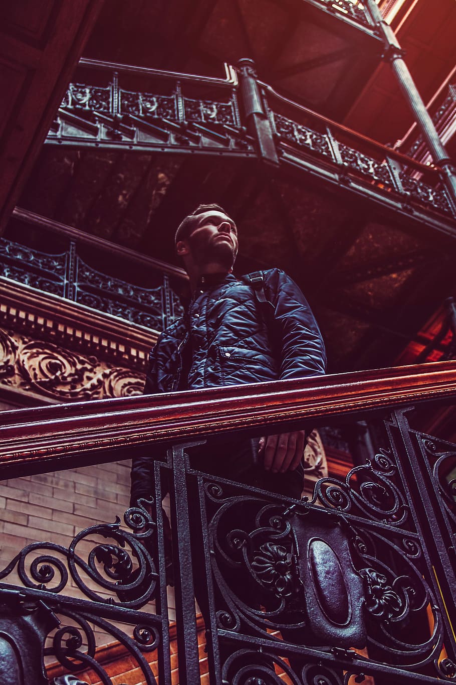 man standing on brown stairs, man looking sideways while standing beside stairs HD wallpaper