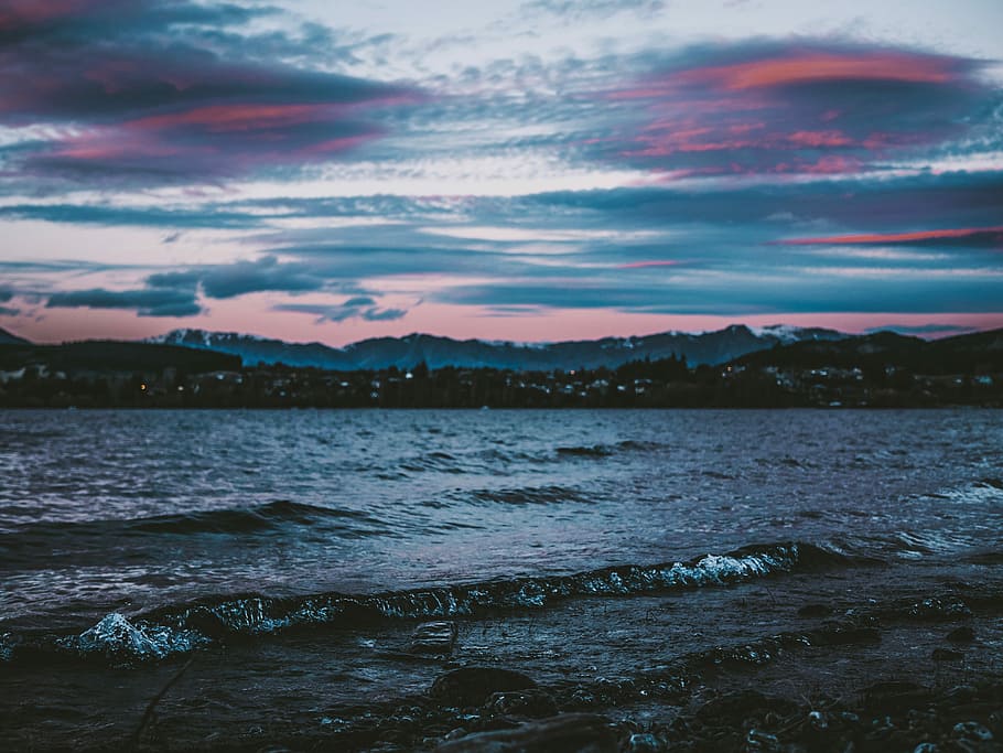 city view near body of water during nightie photography, wavy sea under gray sky HD wallpaper
