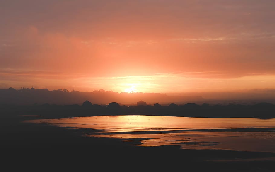 sunset over the horizon with clouds, forest and body of water during sunset HD wallpaper