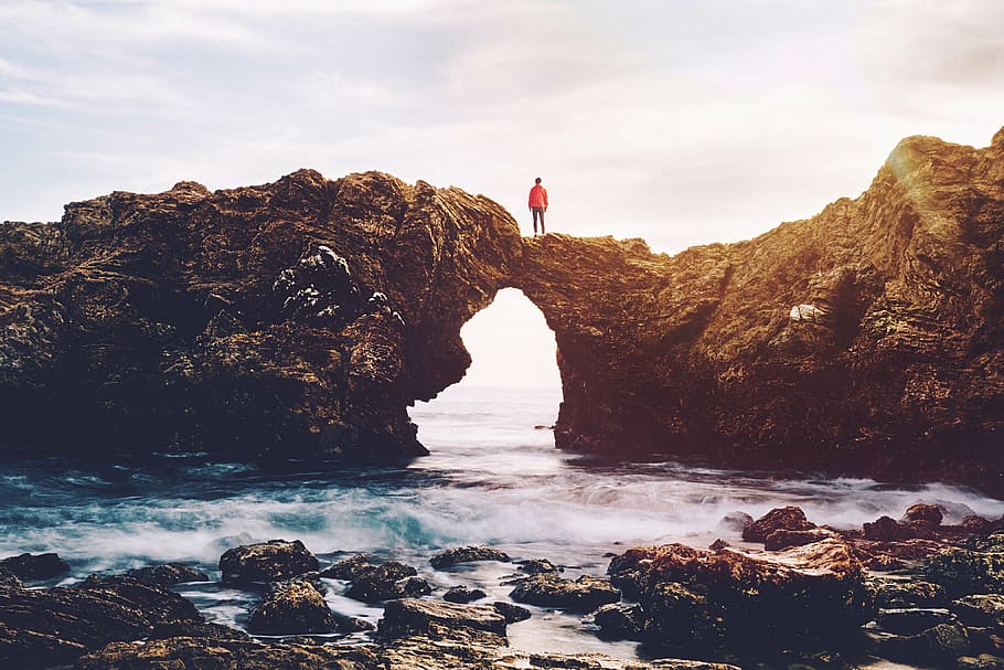 man standing on arch over sea waves, brown, rock, near, body, HD wallpaper