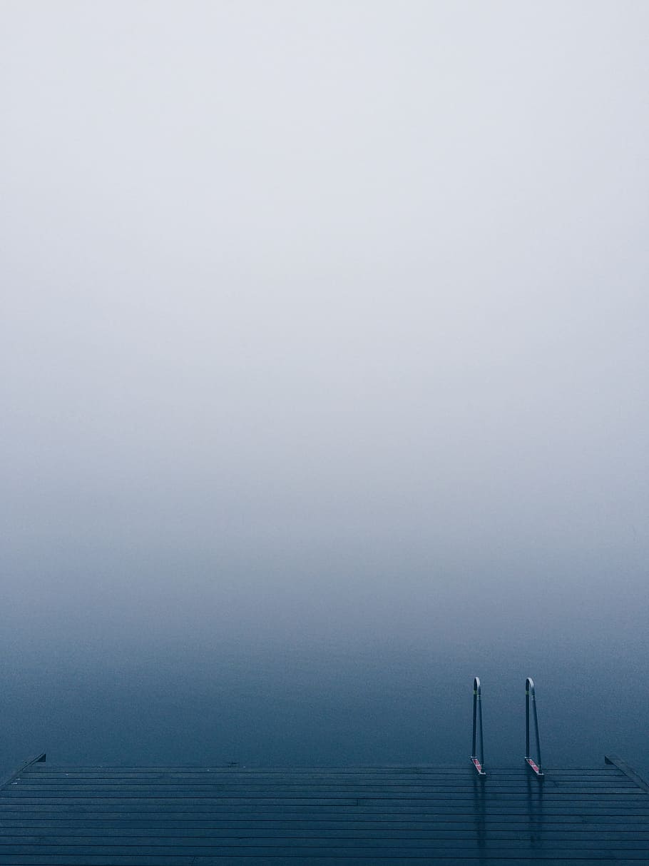 Lake pier with a ladder on serene waters on a foggy day, brown wooden dock near body of water HD wallpaper