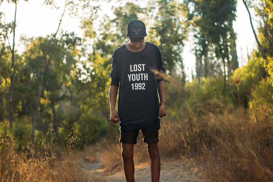 man in black lost youth 1992-printed crew-neck sweater standing between brown grass during daytim, HD wallpaper