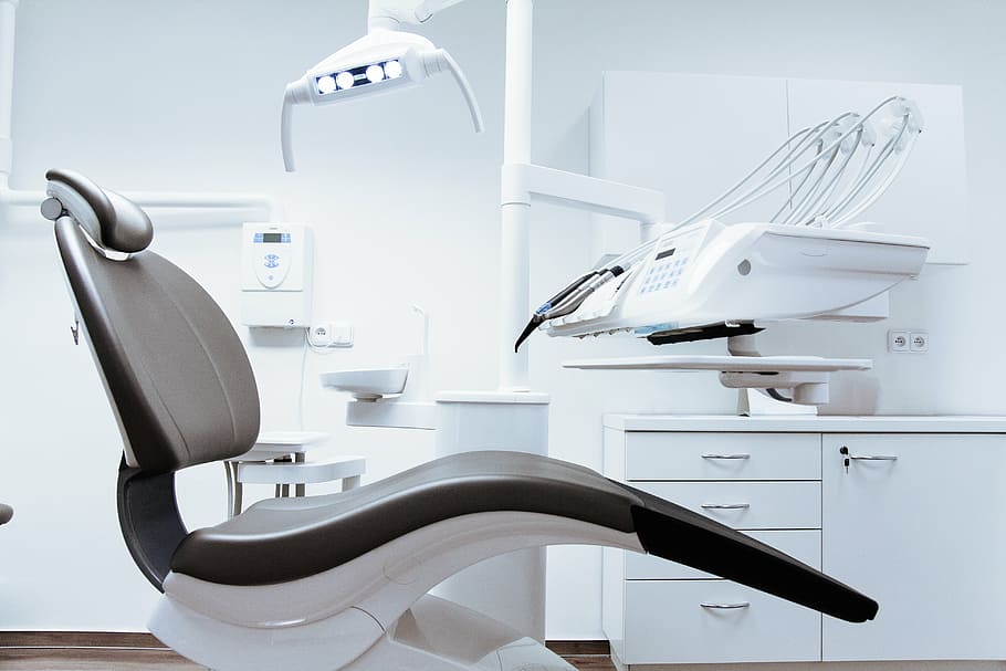 white and black dentist chair near white wooden desk, dental