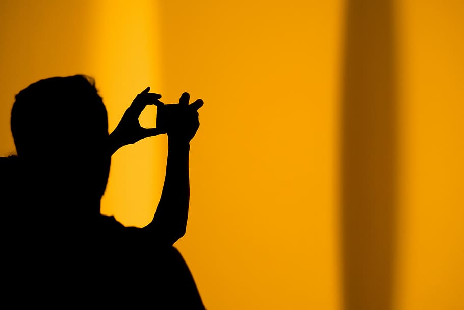 silhouette of man taking photo using camera, silhouette of person taking photo