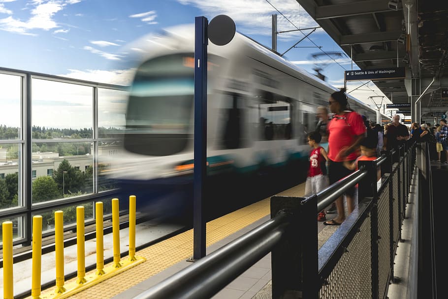 people standing on platform near blue and white train during daytime, time lapse photography of white and blue train near standing people HD wallpaper