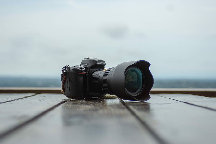 black Nikon DSLR camera on wooden plank floor shallow focus photography, black Nikon DSLR camera on brown surface HD wallpaper