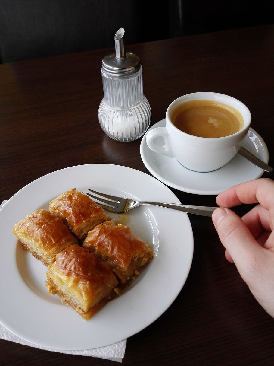 person holding silver fork, baklava, coffee pieces, cake, sweet