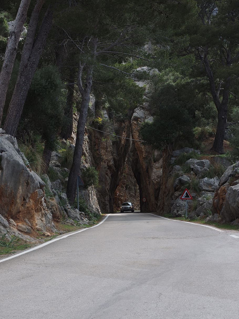 black vehicle on road between rock mountains and trees, breakthrough HD wallpaper